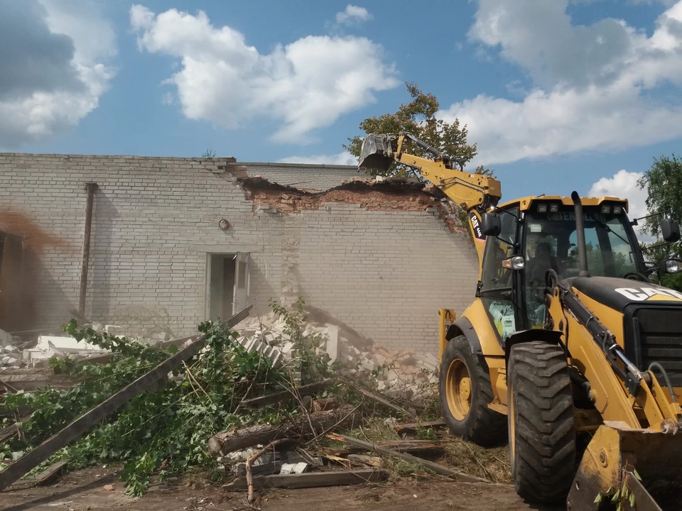 Dismantling work on the demolition of a house in a sanatorium in Kozin is carried out by a bucket excavator CAT 444E